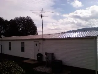New metal roof on a single wide mobile home with a TV antenna in Northfield